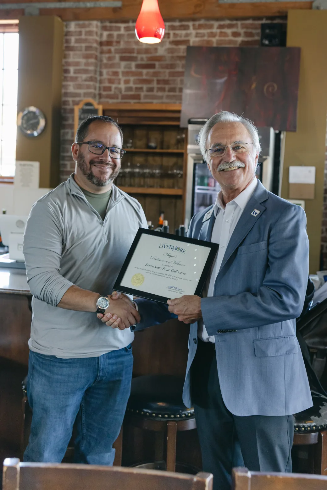 Nick Martinez and Mayor John Marchand holding the Declaration of Welcome at Swirl on the Square